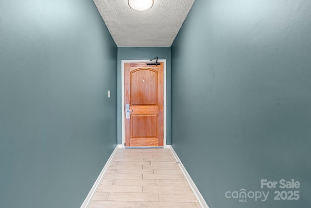 9550 Shore Dr Unit 930, Myrtle Beach, SC 29572 - doorway with a textured ceiling, light wood-type flooring, and baseboards