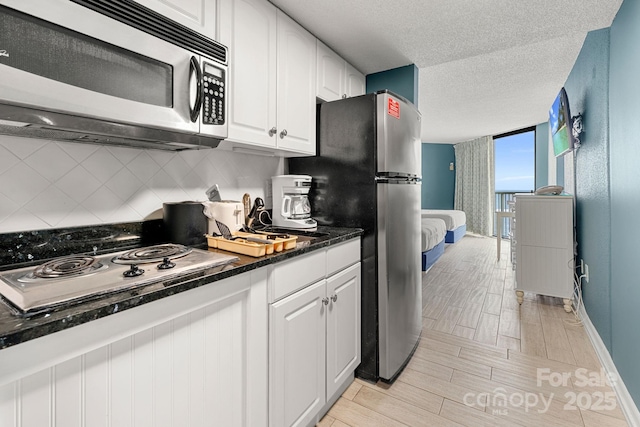 9550 Shore Dr Unit 930, Myrtle Beach, SC 29572 - kitchen featuring stainless steel appliances, backsplash, white cabinets, baseboards, and light wood finished floors