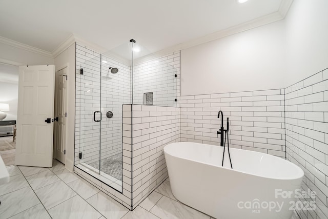 1121 S Wendover Rd, Charlotte, NC 28211 - full bath with tile walls, a freestanding tub, a shower stall, ornamental molding, and marble look tiles