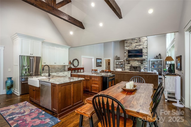 1003 Glory Dr Unit 60, Morganton, NC 28655 - kitchen with appliances with stainless steel finishes, a center island with sink, high vaulted ceiling, beam ceiling, and backsplash