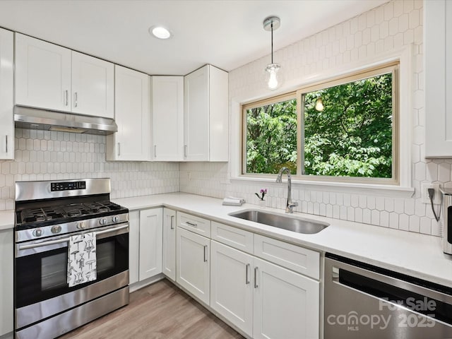 3531 Bon Rea Dr, Charlotte, NC 28226 - kitchen with stainless steel appliances, under cabinet range hood, a sink, light countertops, and decorative backsplash