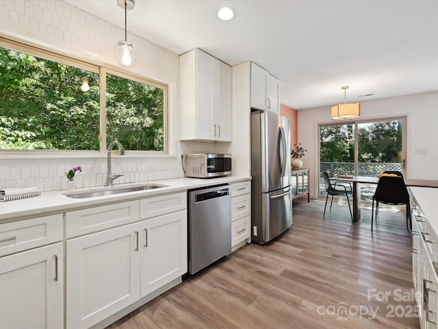 3531 Bon Rea Dr, Charlotte, NC 28226 - kitchen featuring appliances with stainless steel finishes, a sink, white cabinets, light countertops, and backsplash