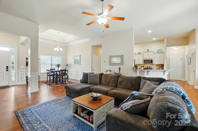 141 Tall Fern Loop, Mooresville, NC 28117 - living room featuring light wood-style flooring, a chandelier, ceiling fan, a tray ceiling, and ornamental molding