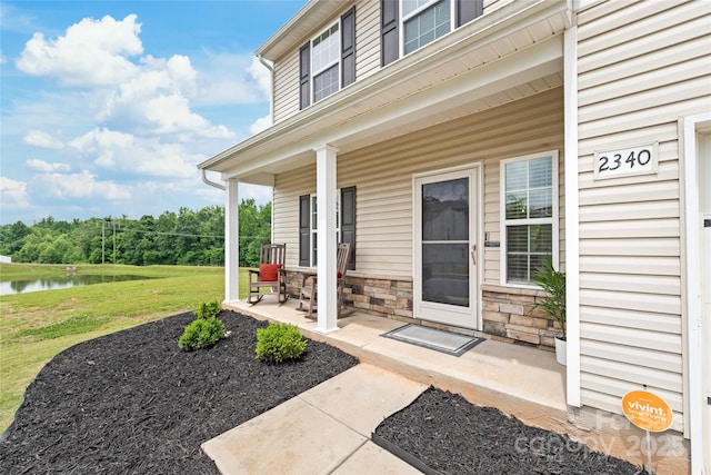 2340 Lanza Dr, Charlotte, NC 28215 - property entrance featuring covered porch, a water view, stone siding, and a lawn