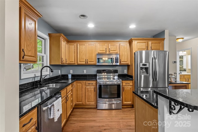 32 Evita Cove Rd, Weaverville, NC 28787 - kitchen featuring stainless steel appliances, a sink, light wood-type flooring, dark stone counters, and recessed lighting
