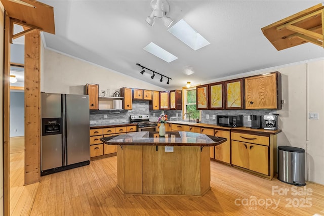 32 Evita Cove Rd, Weaverville, NC 28787 - kitchen with appliances with stainless steel finishes, a skylight, vaulted ceiling, light wood-style flooring, and open shelves