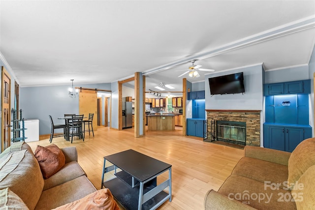 32 Evita Cove Rd, Weaverville, NC 28787 - living area with a barn door, crown molding, ceiling fan, a stone fireplace, and light wood-style flooring