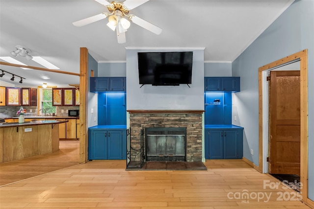 32 Evita Cove Rd, Weaverville, NC 28787 - unfurnished living room with ornamental molding, ceiling fan, a sink, light wood-style floors, and a stone fireplace