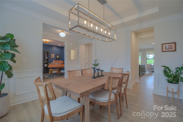 15216 Shallow Ridge Rd, Charlotte, NC 28278 - dining area with a decorative wall, light wood-type flooring, a wainscoted wall, and crown molding