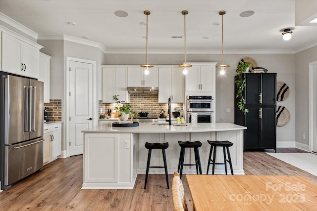 20216 Shaffer Bach Ln, Charlotte, NC 28277 - kitchen featuring appliances with stainless steel finishes, a sink, white cabinets, a breakfast bar area, and light countertops
