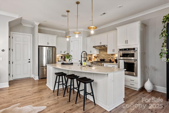20216 Shaffer Bach Ln, Charlotte, NC 28277 - kitchen with stainless steel appliances, a sink, under cabinet range hood, a breakfast bar area, and tasteful backsplash