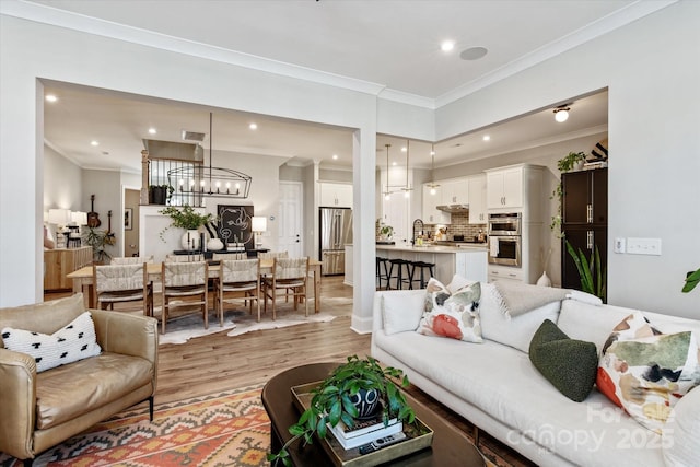 20216 Shaffer Bach Ln, Charlotte, NC 28277 - living room with light wood-type flooring, crown molding, a chandelier, and recessed lighting