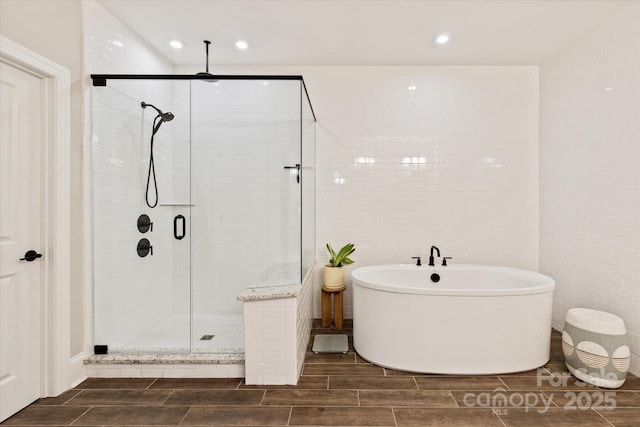 20216 Shaffer Bach Ln, Charlotte, NC 28277 - full bath with a shower stall, wood finish floors, a freestanding tub, recessed lighting, and tile walls