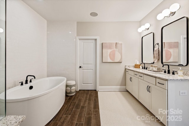 20216 Shaffer Bach Ln, Charlotte, NC 28277 - full bath with double vanity, a freestanding bath, wood finished floors, and baseboards