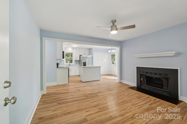5414 Leaford Ct, Charlotte, NC 28227 - unfurnished living room featuring baseboards, a ceiling fan, and light wood-style flooring