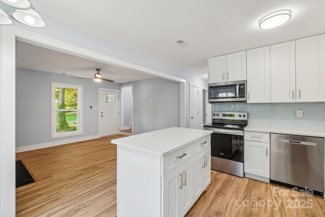 5414 Leaford Ct, Charlotte, NC 28227 - kitchen featuring stainless steel appliances, tasteful backsplash, light countertops, light wood-type flooring, and white cabinets