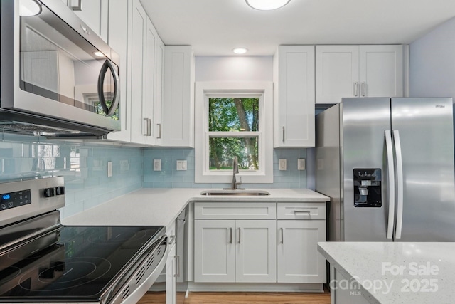5414 Leaford Ct, Charlotte, NC 28227 - kitchen featuring stainless steel appliances, a sink, decorative backsplash, and white cabinets