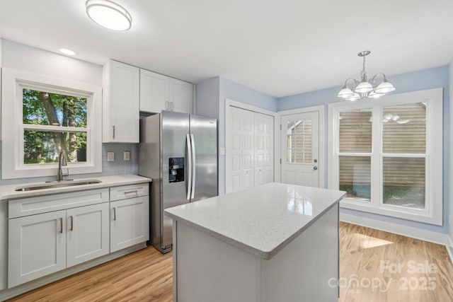 5414 Leaford Ct, Charlotte, NC 28227 - kitchen with stainless steel fridge with ice dispenser, a sink, light wood-style floors, a chandelier, and decorative light fixtures