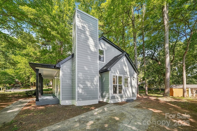5414 Leaford Ct, Charlotte, NC 28227 - back of property featuring a chimney, view of scattered trees, and an outdoor structure