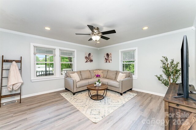 910 W A St, Kannapolis, NC 28081 - living area featuring healthy amount of natural light, wood finished floors, ceiling fan, ornamental molding, and baseboards