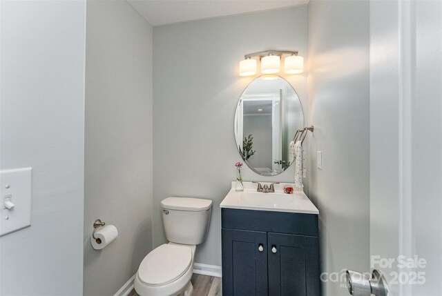 910 W A St, Kannapolis, NC 28081 - half bathroom featuring toilet, vanity, baseboards, and wood finished floors