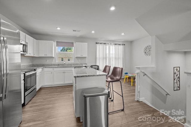 718 Dillon Way Unit 38, Fort Mill, SC 29715 - kitchen with appliances with stainless steel finishes, a center island, white cabinetry, light stone counters, and recessed lighting