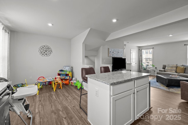 718 Dillon Way Unit 38, Fort Mill, SC 29715 - kitchen featuring open floor plan, a center island, dark wood finished floors, a kitchen breakfast bar, and light stone countertops