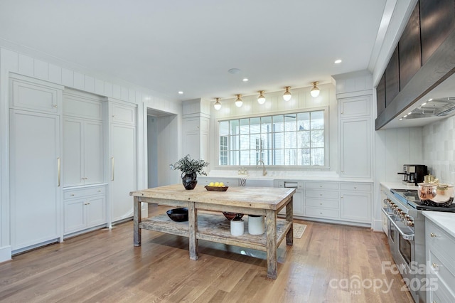 2270 New Gray Rock Rd, Fort Mill, SC 29708 - kitchen with wall chimney exhaust hood, double oven range, a sink, light wood-style floors, and light countertops