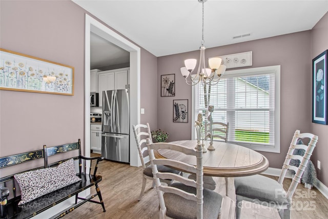 1155 Rudder Cir, Salisbury, NC 28146 - dining space with a chandelier, light wood finished floors, and baseboards