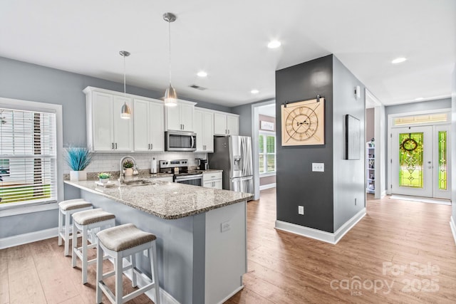 1155 Rudder Cir, Salisbury, NC 28146 - kitchen featuring stainless steel appliances, baseboards, a sink, a breakfast bar area, and tasteful backsplash