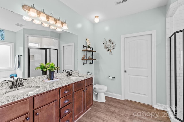 1155 Rudder Cir, Salisbury, NC 28146 - bathroom featuring a stall shower, double vanity, toilet, wood finished floors, and baseboards