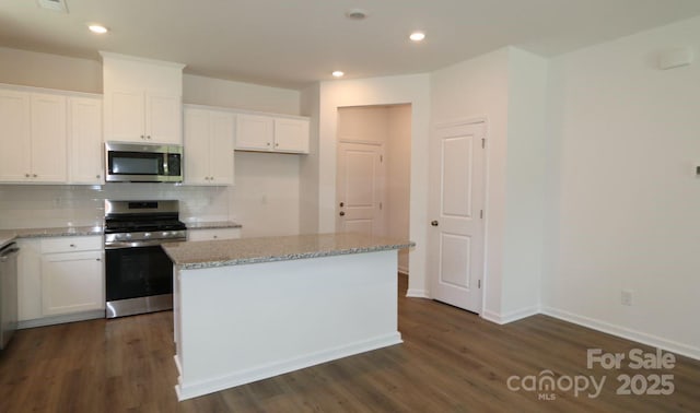1922 Highland Park Dr, Charlotte, NC 28269 - kitchen with appliances with stainless steel finishes, tasteful backsplash, dark wood-style floors, white cabinetry, and recessed lighting