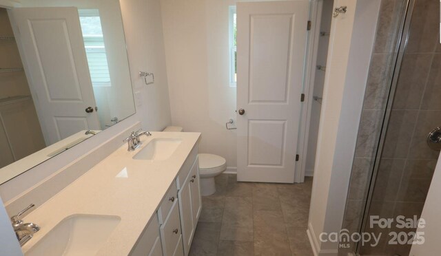 1922 Highland Park Dr, Charlotte, NC 28269 - bathroom with double vanity, tiled shower, toilet, and baseboards