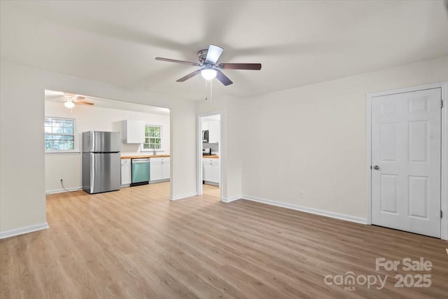 818 Stowe Ln, Gastonia, NC 28056 - unfurnished living room with ceiling fan, light wood-style flooring, and baseboards