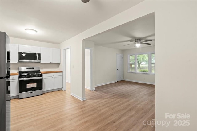 818 Stowe Ln, Gastonia, NC 28056 - kitchen with appliances with stainless steel finishes, a ceiling fan, white cabinetry, and light wood-style floors