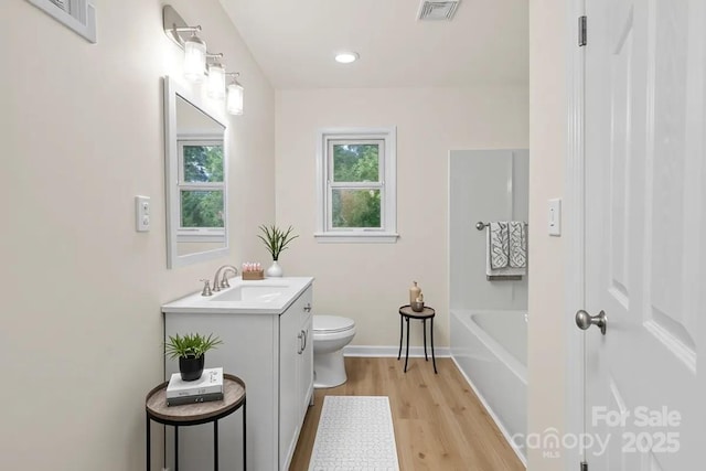818 Stowe Ln, Gastonia, NC 28056 - bathroom featuring toilet, vanity, wood finished floors, a tub, and baseboards