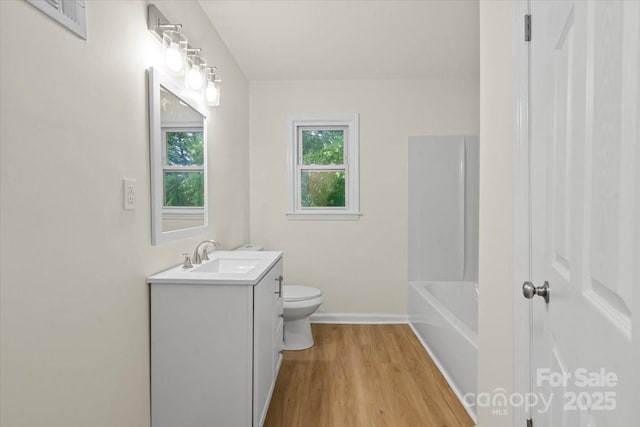 818 Stowe Ln, Gastonia, NC 28056 - bathroom with vanity, toilet, wood finished floors, and baseboards