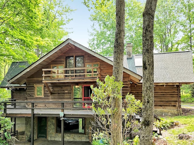 429 Biodome Dr, Waynesville, NC 28785 - rear view of house featuring roof with shingles, a chimney, a patio, a wooden deck, and stone siding