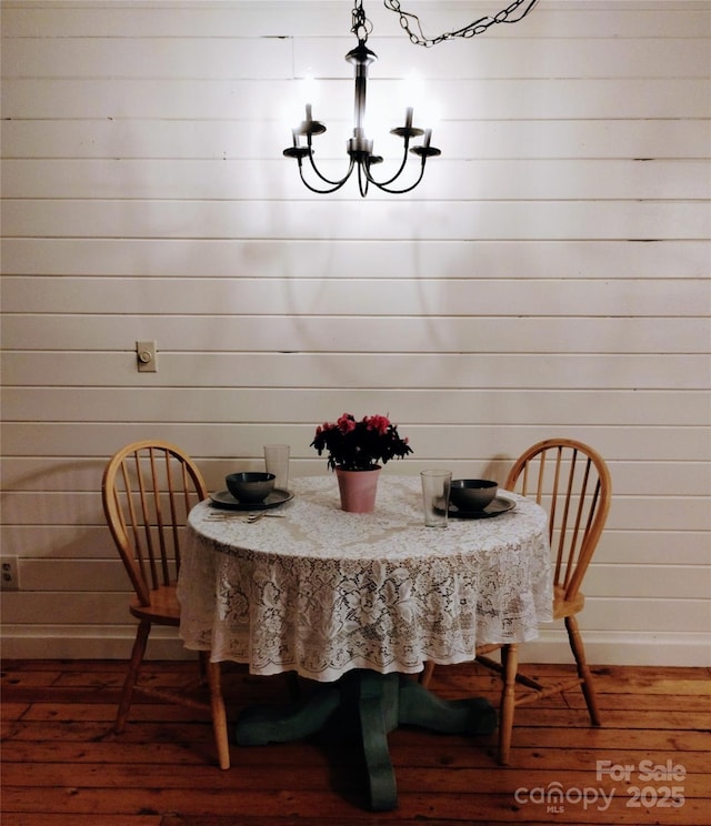 429 Biodome Dr, Waynesville, NC 28785 - dining space with wood-type flooring, a chandelier, baseboards, and wood walls