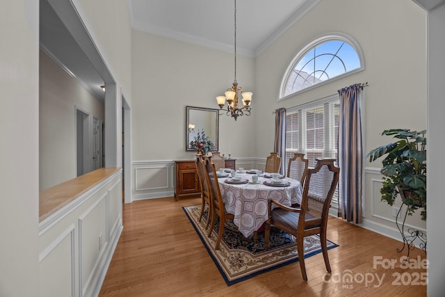 10501 Mount Olive Estates Dr Unit 7, Mount Pleasant, NC 28124 - dining space with ornamental molding, a decorative wall, a chandelier, light wood finished floors, and a wainscoted wall