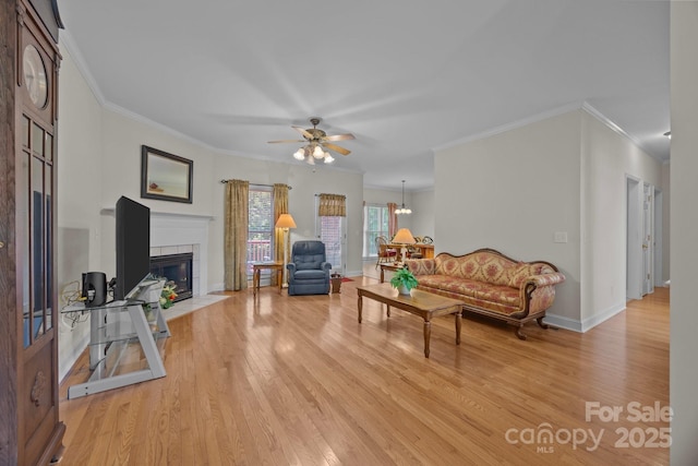 10501 Mount Olive Estates Dr Unit 7, Mount Pleasant, NC 28124 - living room featuring light wood-style flooring, a tiled fireplace, crown molding, ceiling fan, and baseboards