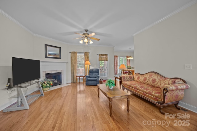 10501 Mount Olive Estates Dr Unit 7, Mount Pleasant, NC 28124 - living area with light wood-style flooring, ornamental molding, a tiled fireplace, a ceiling fan, and baseboards