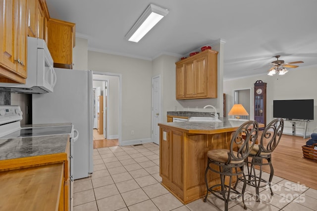 10501 Mount Olive Estates Dr Unit 7, Mount Pleasant, NC 28124 - kitchen with electric range oven, white microwave, a sink, a peninsula, and ornamental molding