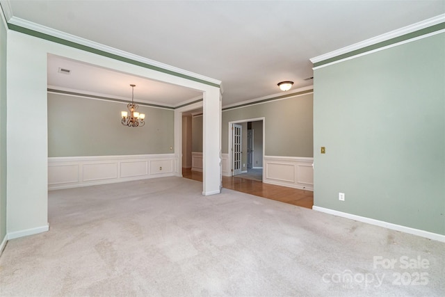 9419 Olivia Ln, Charlotte, NC 28277 - carpeted spare room featuring a chandelier, ornamental molding, wainscoting, and a decorative wall