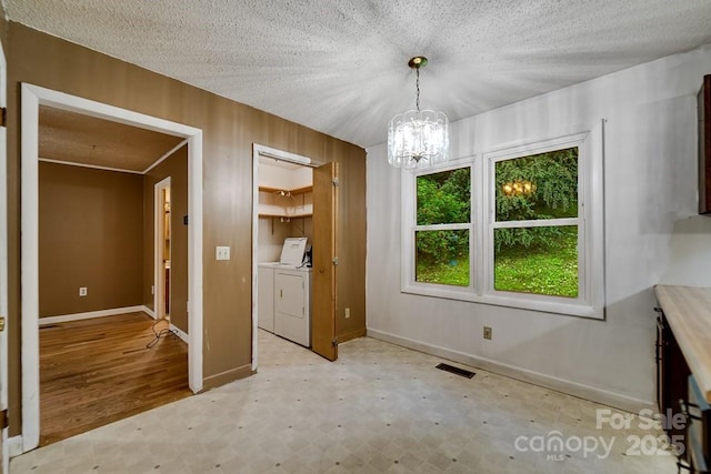 302 Mitchell Rd, Sylva, NC 28779 - unfurnished dining area featuring independent washer and dryer, light flooring, a chandelier, baseboards, and wood walls