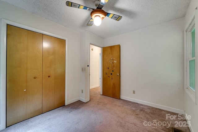 302 Mitchell Rd, Sylva, NC 28779 - unfurnished bedroom featuring carpet flooring, a textured ceiling, baseboards, a closet, and a ceiling fan