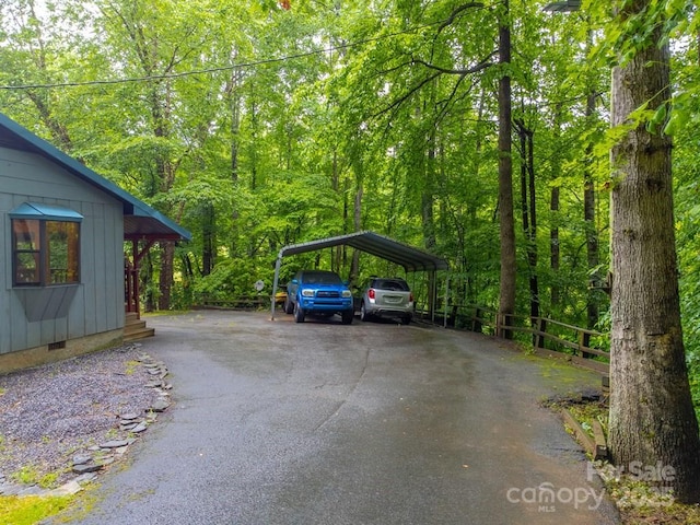 302 Mitchell Rd, Sylva, NC 28779 - view of parking / parking lot with asphalt driveway, a detached carport, and a forest view