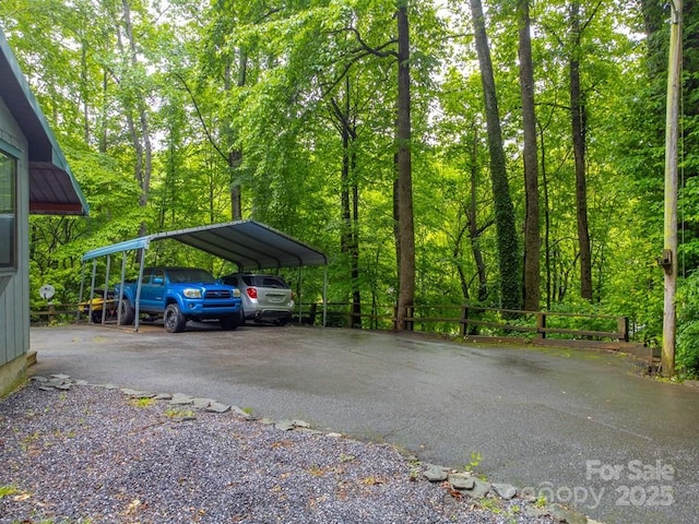 302 Mitchell Rd, Sylva, NC 28779 - view of vehicle parking featuring asphalt driveway, a carport, and a wooded view
