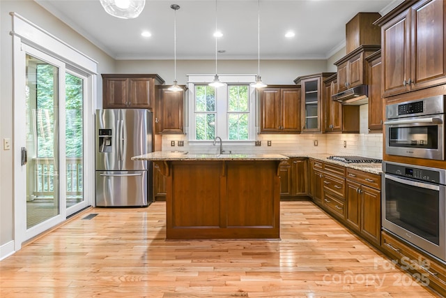 1 E Owl Creek Ln, Fairview, NC 28730 - kitchen featuring appliances with stainless steel finishes, light stone countertops, tasteful backsplash, crown molding, and a center island