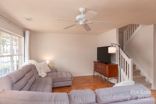 10548 English Setter Way, Charlotte, NC 28269 - living area featuring a textured ceiling, stairs, wood finished floors, a ceiling fan, and baseboards
